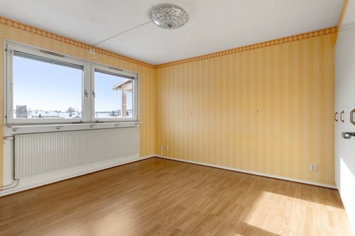 Sovrum med gott om förvaring i hel garderobsvägg.