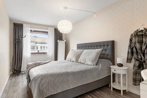 Rymligt sovrum med plats för förvaringsmöbel.